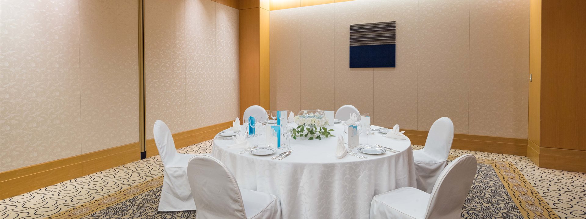 "Yamayuri" is a small banquet hall located on the second basement floor of the Yokohama Bay Hotel Tokyu. Six chairs are arranged around a round table that has been set for a formal dinner.