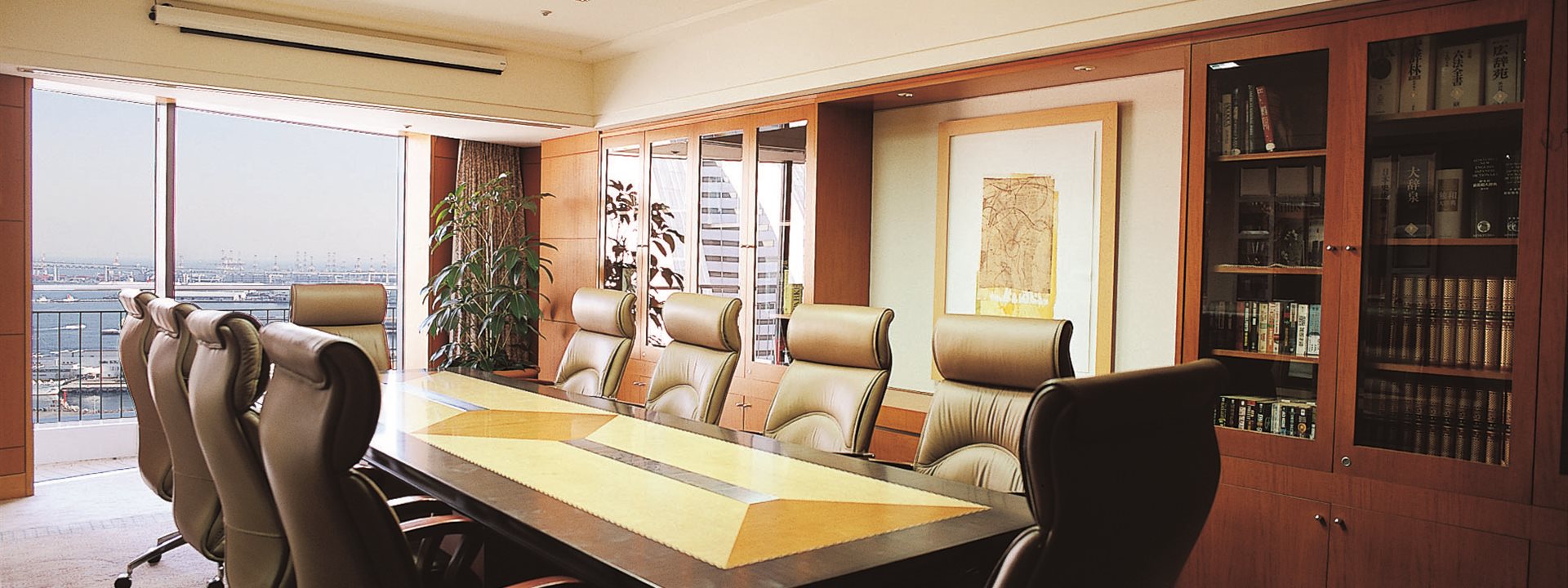 The "The Library" conference room on the 23rd floor of the Yokohama Bay Hotel Tokyu. Ten chairs surround a table placed in the center of the room. Cabinets are built into the walls.